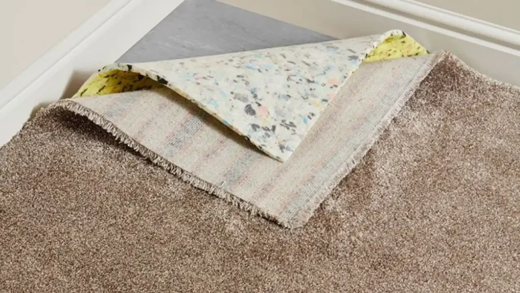 Roll of carpet underlay being laid before carpet installation in a Dubai home