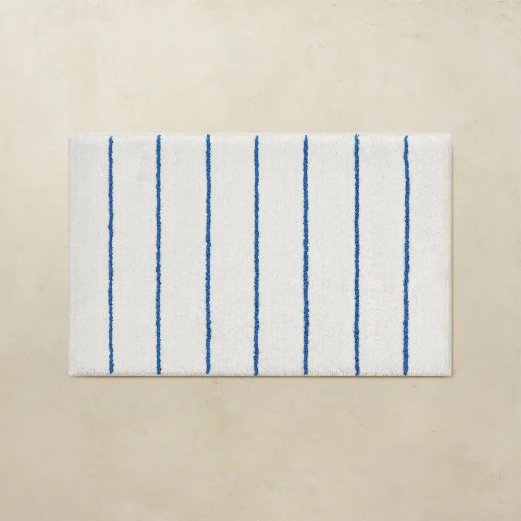 White bathroom rug with blue vertical stripes