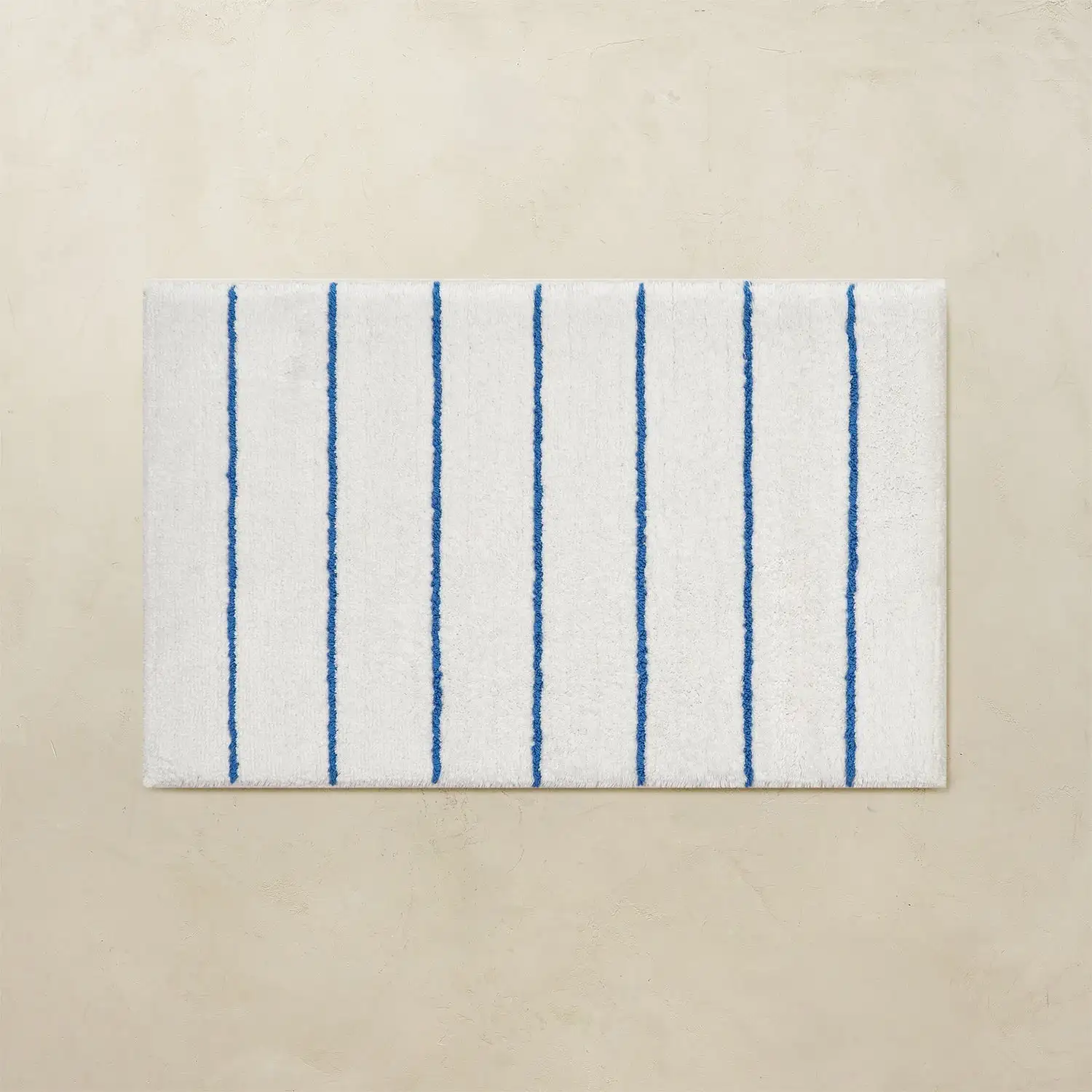 White bathroom rug with blue vertical stripes